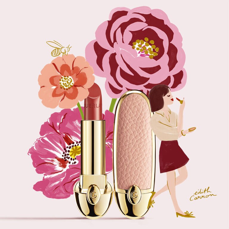 A WOMAN APPLYING LIPSTICK LEANING ON A GUERLAIN ROUGE G LIPSTICK WITH FLOWERS IN THE BACKGROUND